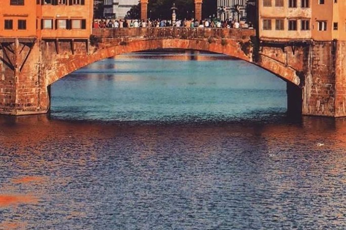 a bridge over water with a city in the background